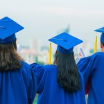 high school graduates overlooking a city