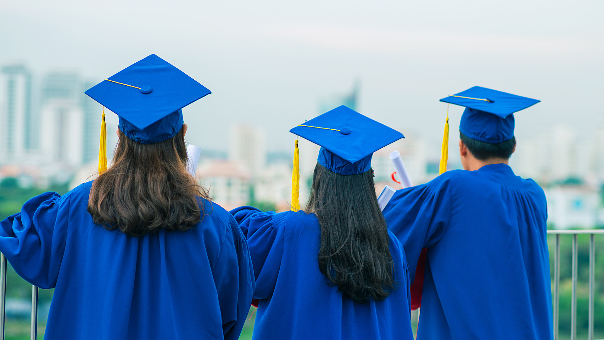 high school graduates overlooking a city